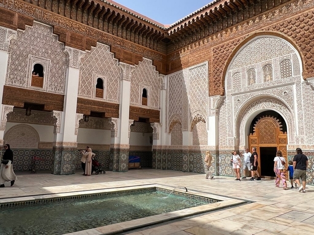 People exploring a historic building with intricate mosaic and tilework.