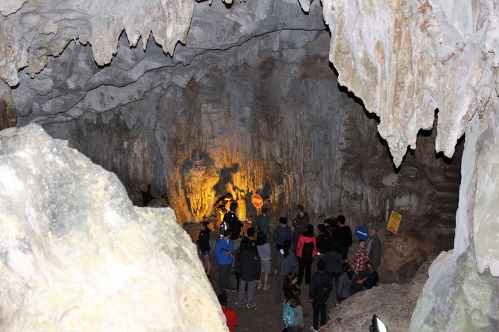       Tourists exploring a cave illuminated by lights
  