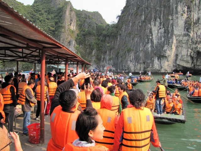       Crowded dock area with people boarding boats
  