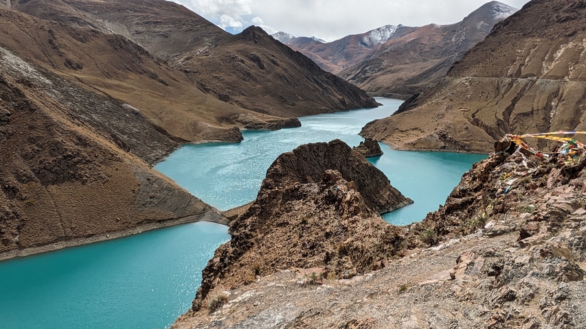       Serpentine turquoise river through rugged mountainous terrain.
  
