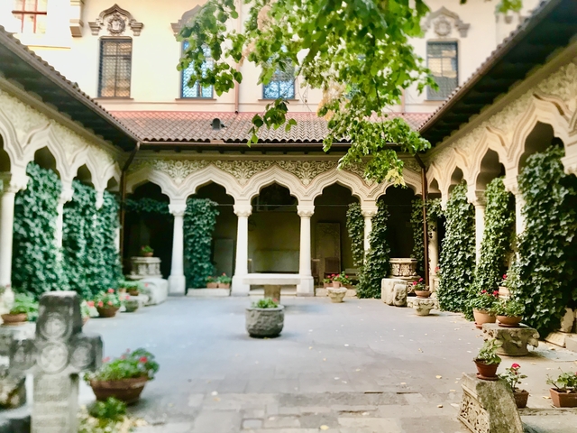 Ornate courtyard with arches and greenery.