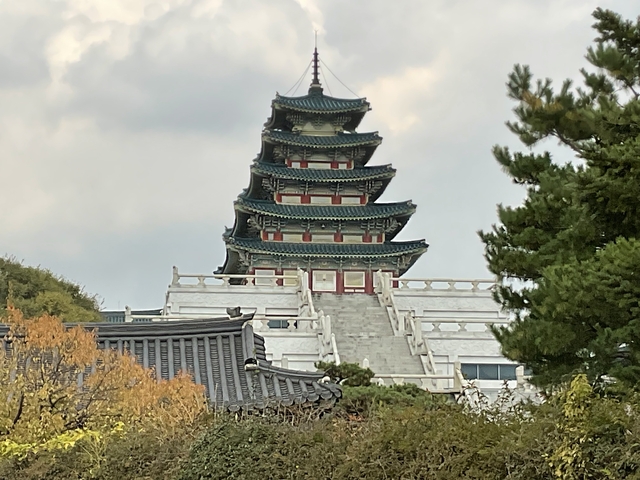       Traditional pagoda-style building with cloudy sky.
  