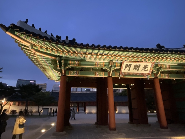       Colorful traditional gate illuminated at dusk.
  