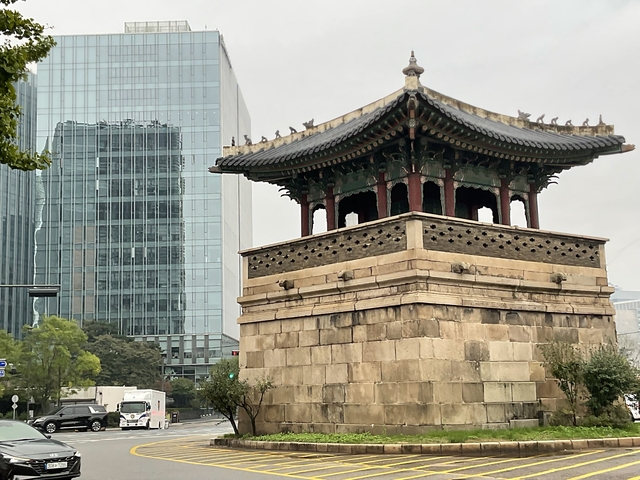       Traditional Korean structure near modern skyscrapers.
  
