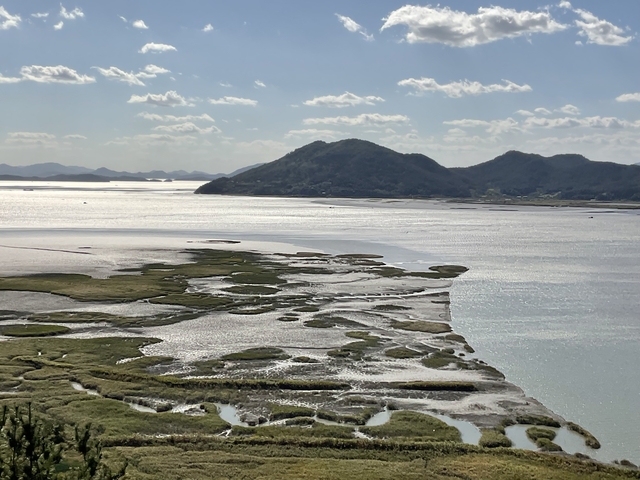       Coastal view with mountains and clear sky.
  