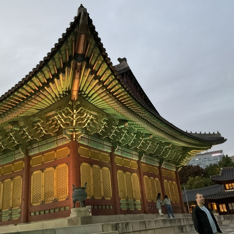       Illuminated traditional Korean building at dusk.
  
