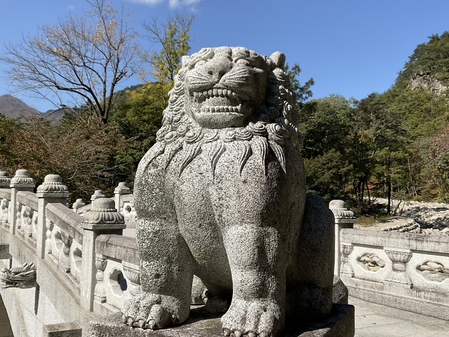       Stone statue of a lion on a sunny day.
  
