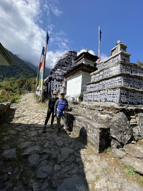 Two people posing in front of religious monuments.