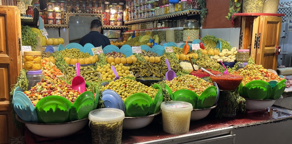       Colorful market stall with various pickled products.
  