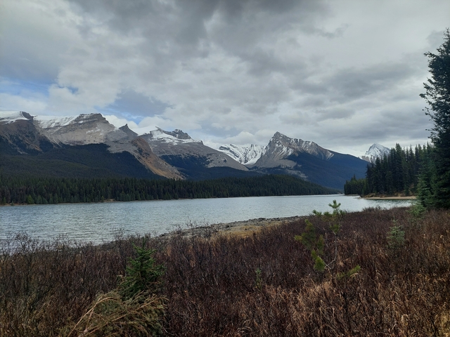 A tranquil lake with snow-capped mountains in the background.