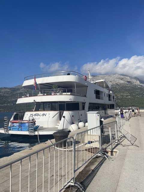       A ship docked with mountains in the background.
  