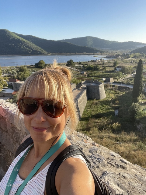       Close-up of a woman with sunglasses in a scenic landscape.
  