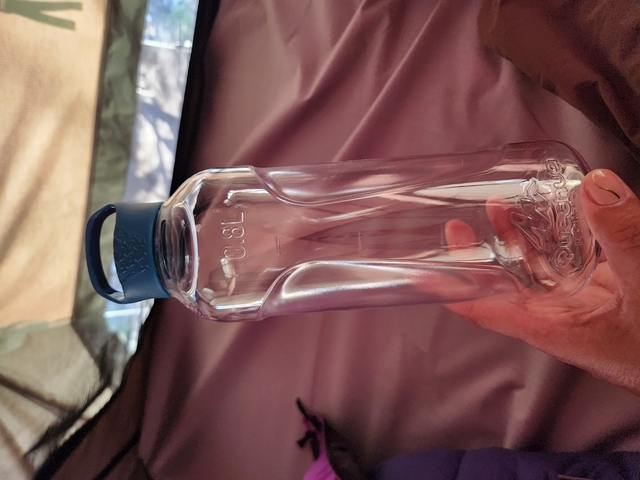 A clear plastic bottle being held.