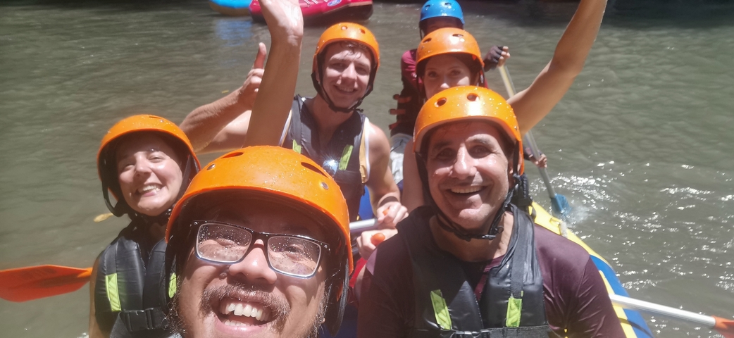 Group of people on a rafting adventure wearing safety helmets.