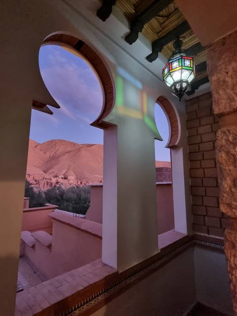 View through ornate arches with a landscape in the background.