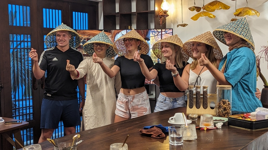 People posing together wearing traditional hats.
