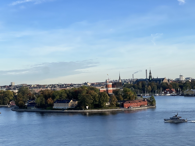 Panoramic view of a city with waterfront and historic buildings.