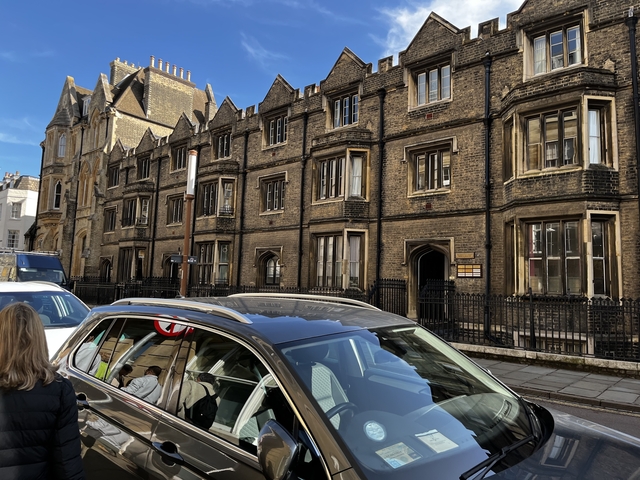 Historic stone building with gothic architecture in a city street.