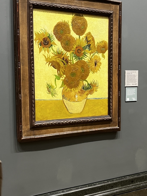       Painting of sunflowers in a museum setting.
  