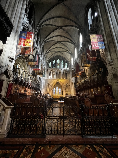 Interior of a historic cathedral with vaulted ceilings and stained glass.