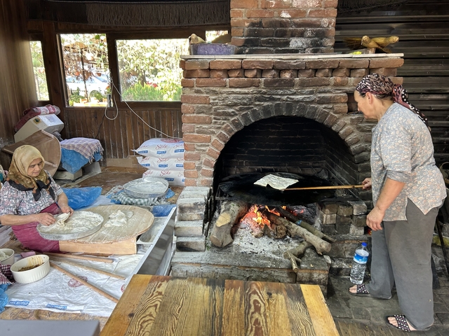Women preparing traditional bread over an open fire.