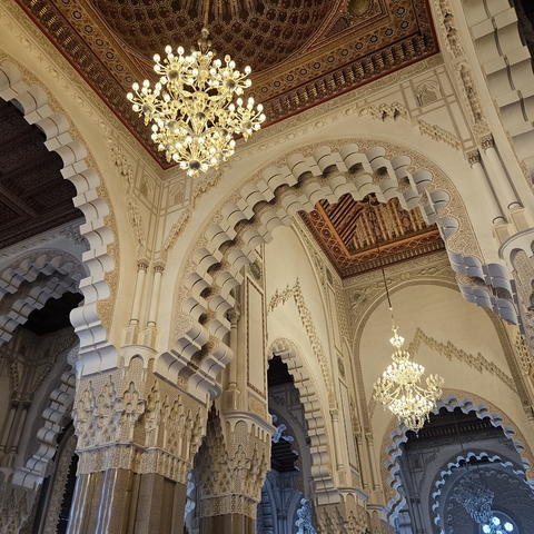       Ornate interior architecture with arches and chandeliers.
  