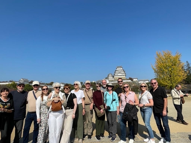 Group photo with a castle and clear blue sky.