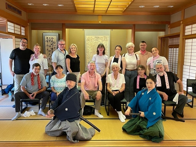 Group photo in a traditional Japanese room with people dressed in cultural attire.