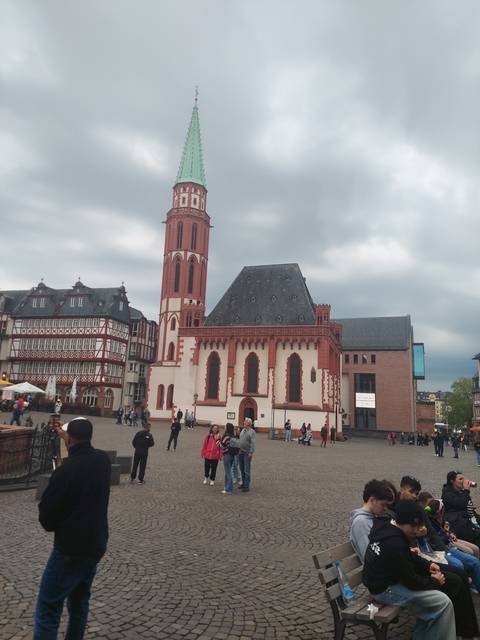 A church with red and white facade and town square.