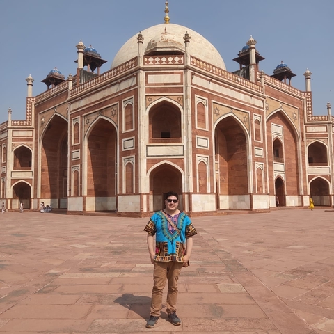Man posing in front of a historic building in New Delhi.