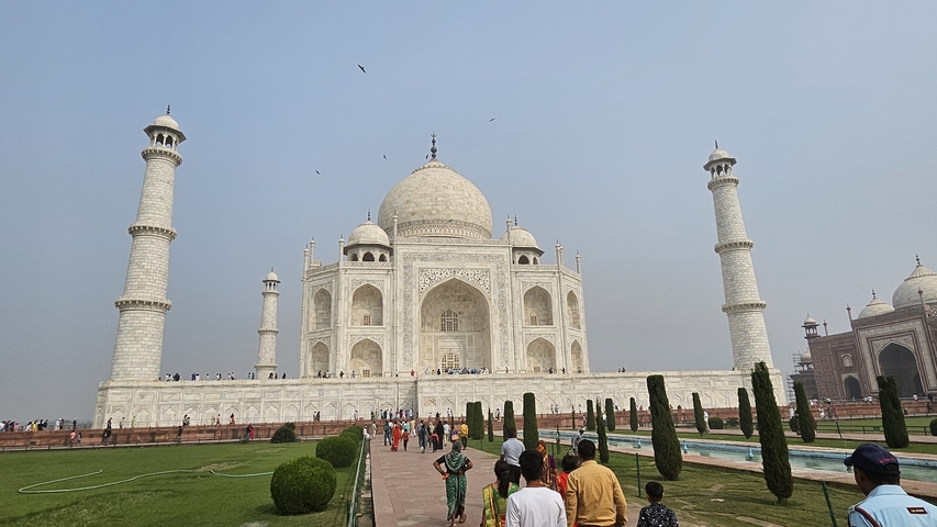 Taj Mahal with gardens and visitors.