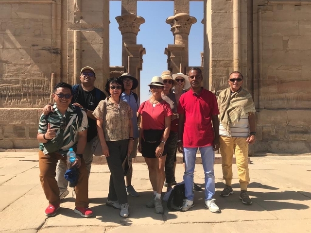 Group of tourists posing at an archaeological site.