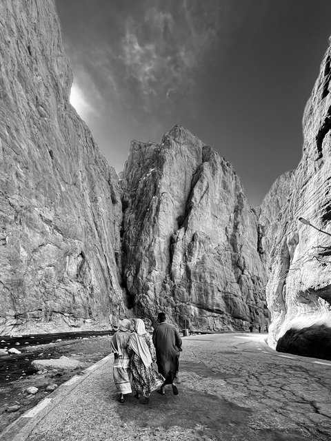Tall, rugged cliff face in a black and white image.