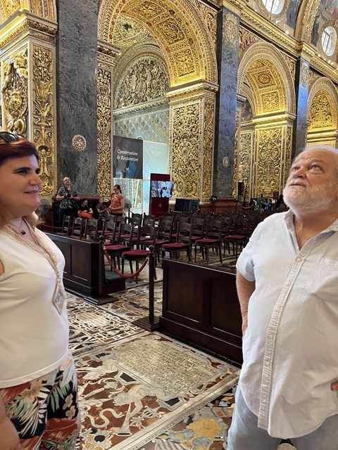 Two people in an ornate interior space, observing the surroundings.