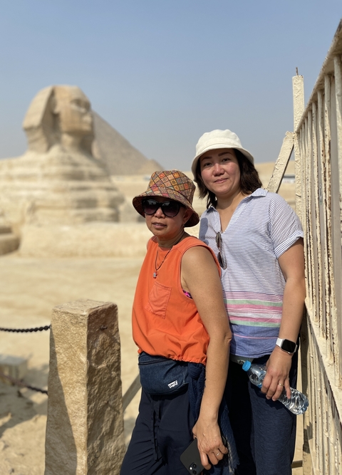 Two people posing with a Sphinx statue