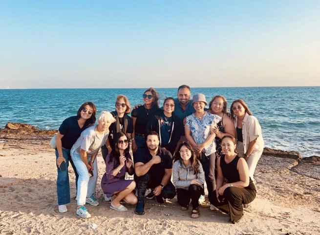       Group by the sea posing for a photo
  