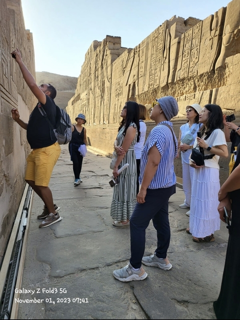       Group looking at hieroglyphics on a wall
  