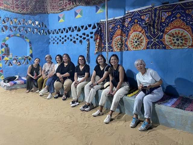 Seven people sitting in a colorful room