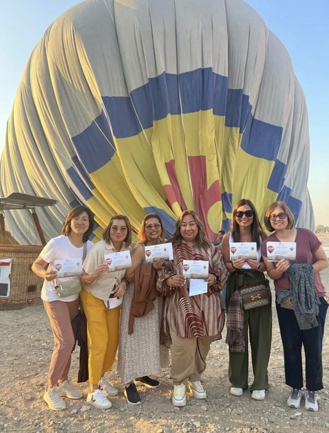       Group with certificates in front of folded balloon
  