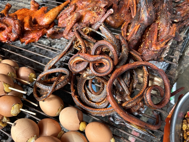       Various grilled foods displayed at a market.
  