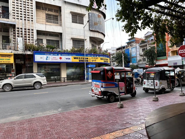       Street scene with tuk-tuks and cars
  