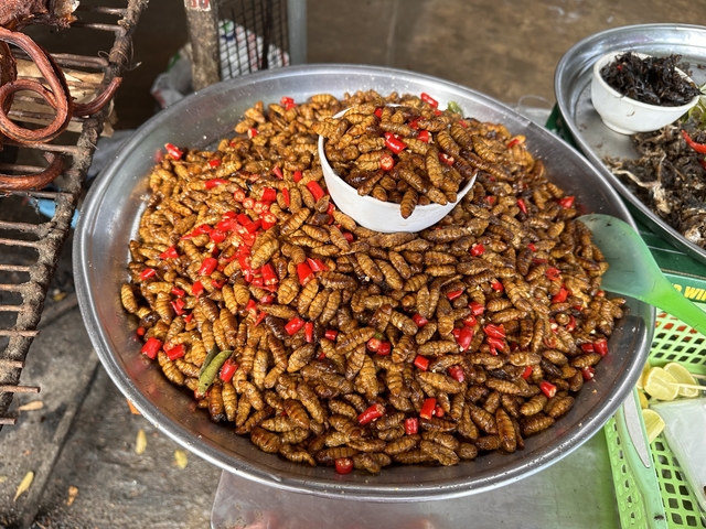       Bowl full of chili-covered insects.
  