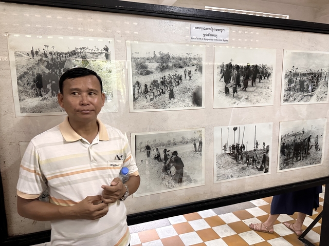       Man standing in front of historical photos
  
