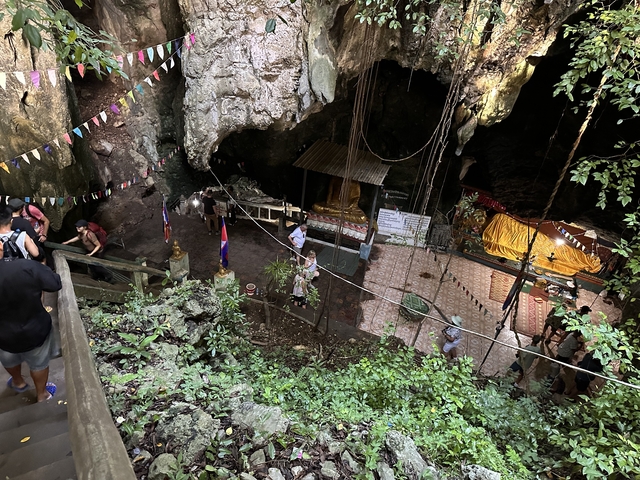       Cave with a shrine and people exploring.
  