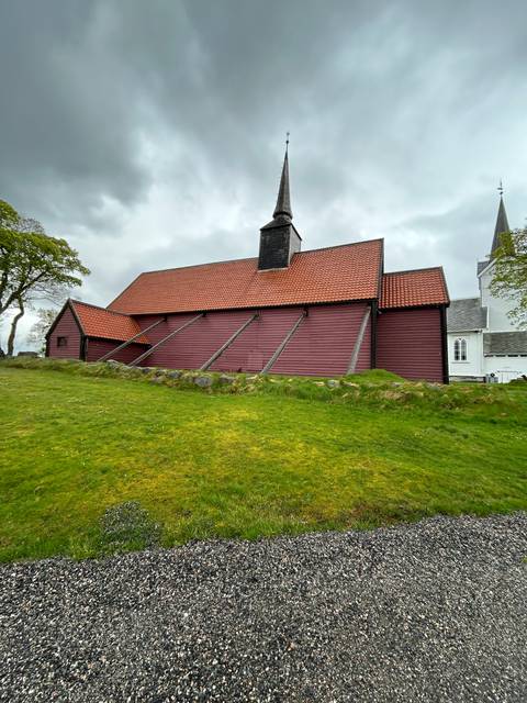 Red wooden church with a tall spire.