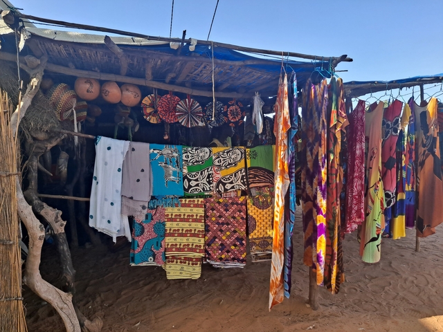       Colorful fabrics and decorations in a rustic market setting.
  