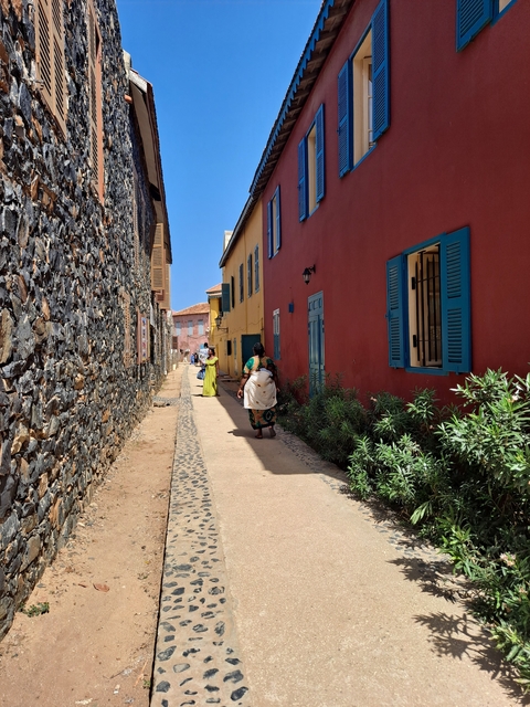       Colorful street with traditional buildings and people walking.
  
