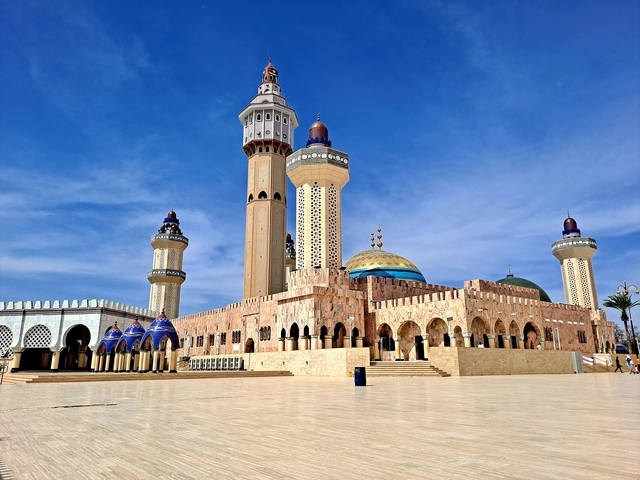       Magnificent mosque with ornate towers and a large courtyard.
  