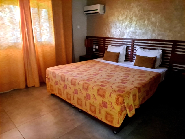       Cozy hotel room with inviting bed and curtains.
  