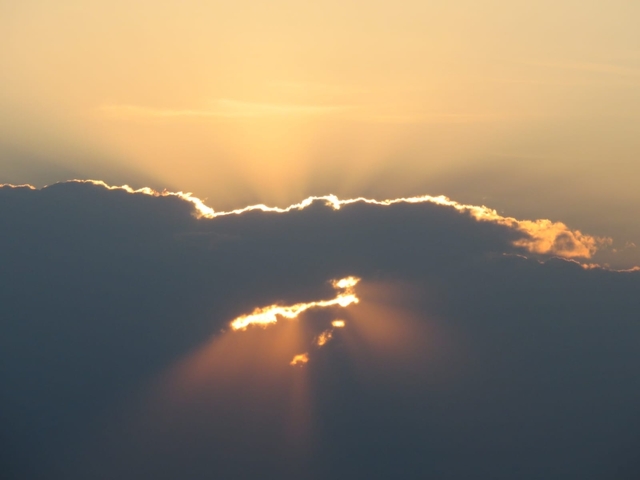 Sunlight streaming through clouds, creating a dramatic effect.